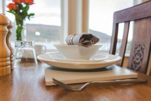 een witte kom op een houten tafel met een servet bij Clyde View B&B in Dunoon