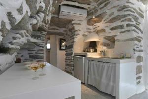 una cocina con 2 copas de vino en una barra en Tranquil cottage, en Agios Sostis
