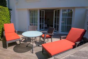 a patio with chairs and a table and a table and chairs at Strandhotel Fontana in Timmendorfer Strand