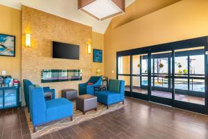 a waiting room with blue chairs and a flat screen tv at Comfort Inn & Suites in Mojave