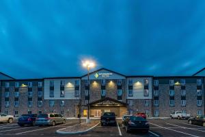 un hotel con coches estacionados en un estacionamiento en WoodSpring Suites Indianapolis Zionsville, en Whitestown