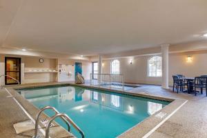 a large swimming pool with blue water in a building at Comfort Suites Stevensville - St Joseph in Stevensville