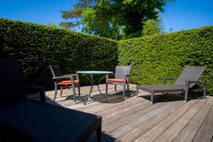 a patio with chairs and a table and a hedge at Strandhotel Fontana in Timmendorfer Strand