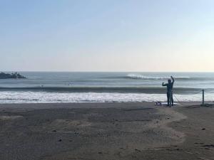 a man standing on a beach with a kite at KAI Ichinomiya in Ichinomiya