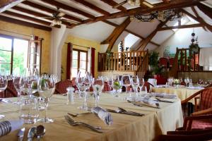 a table with wine glasses on it in a restaurant at Auberge de la Vieille Ferme in Le Meux