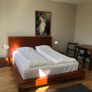 a bedroom with a large bed with a picture on the wall at Seven Sisters Apartments in Liepāja