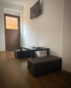 Zimmer mit einem Tisch, einer Bank und einer Tür in der Unterkunft ULLYSSES GUEST HOUSE in Braşov