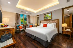 Hanoi Dalvostro Valentino Hotel & Spa في هانوي: غرفة الفندق بسرير كبير ومكتب