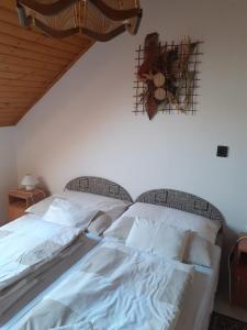 1 dormitorio con 1 cama con sábanas blancas en Anna vendégház en Balatonakali