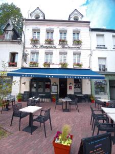 un bâtiment avec des tables et des chaises devant lui dans l'établissement Les Remparts, à Montreuil-sur-Mer