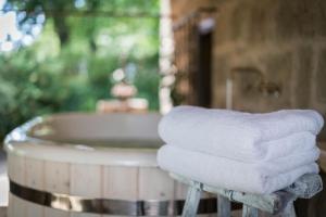 una pila de toallas sentadas en un taburete junto a una bañera en Agriturismo Biologico Sant'Egle en Sorano