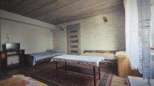 ニジツァにあるAgroturystyka Szerokopaśのベッド2台とテーブルが備わる客室です。