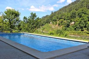 a swimming pool with a mountain in the background at Casa Ferreira in Terras de Bouro