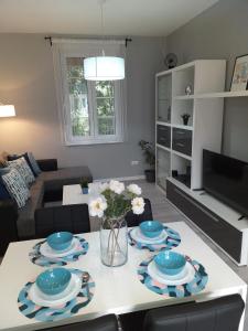 a living room with a table with plates and flowers on it at ArenaStreet Apartmani in Pula