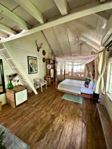 ein Schlafzimmer mit einem Bett in einem Zimmer mit Holzböden in der Unterkunft Memo's Beach in Nilaveli