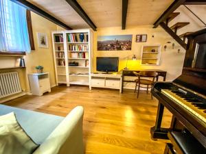 una sala de estar con piano y una habitación con escritorio en Without Name Apartment, en Bolonia