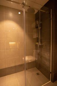 斯里巴加灣市的住宿－Higher Hotel，浴室内带卫生间的玻璃淋浴间