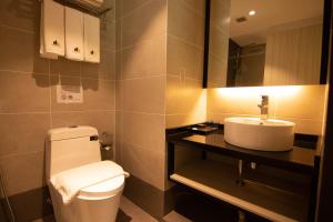 a bathroom with a toilet and a sink at Higher Hotel in Bandar Seri Begawan