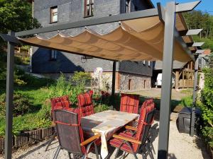 stół i krzesła pod parasolem na dziedzińcu w obiekcie Ferienwohnung Baacke w mieście Ruhla