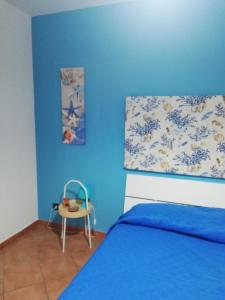 una camera blu con un letto e un tavolo di Casa Vacanza Blue Sea a San Vito lo Capo