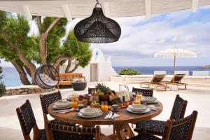 a table on a patio with a view of the ocean at Villa Santa Katerina - Sea View & Outdoor Hot Tub in Platis Gialos