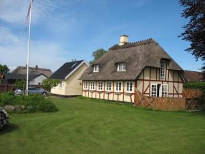 una casa grande con techo de paja en un patio en Thurø Kro B&B, en Svendborg