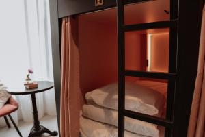 a closet with a glass door with a bed at Durty Nelly's Inn in Amsterdam