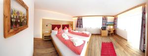 una camera da letto con un letto grande con cuscini rossi di Hotel Eggerhof a Saalbach Hinterglemm