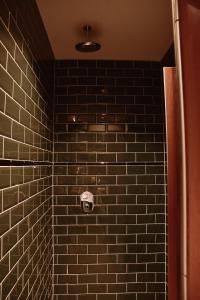 a bathroom with a urinal and a tile wall at Durty Nelly's Inn in Amsterdam