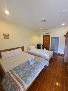 2 Betten in einem Hotelzimmer mit blauen Handtüchern in der Unterkunft Green View Resort Tha Yang in Phetchaburi