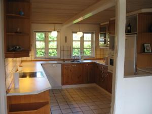 a kitchen with wooden cabinets and a white appliance at Thurø Kro B&B in Svendborg