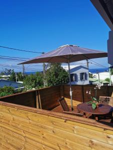 eine Terrasse mit einem Tisch und einem Sonnenschirm in der Unterkunft T3 - 87m2 - Résidence Georgette in Terre Sainte