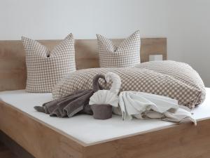 łóżko z poduszkami i dwa łabędzie na nim w obiekcie Alpenflair w mieście Berwang