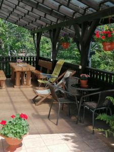 un patio con sillas y mesas bajo una pérgola de madera en Apartamenty pokoje INA, en Ustroń