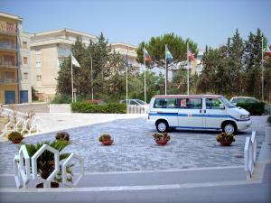 a blue van parked in a parking lot with flags at Torre Del Sole in Terracina