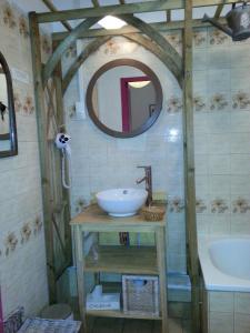 W łazience znajduje się umywalka, lustro i wanna. w obiekcie Auberge Cocagne w mieście Avèze