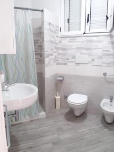 een badkamer met een wastafel, een toilet en een douche bij Il fortino in Otranto