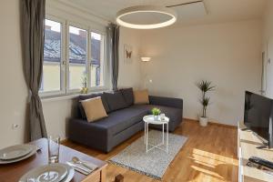 ein Wohnzimmer mit einem Sofa und einem Tisch in der Unterkunft Helle und gemütliche Wohnung in zentraler Lage in Graz
