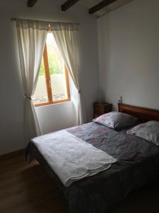 a bedroom with a bed and a window at Residence Le petit paradis - La petite maison in Labastide-Rouairoux