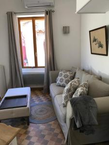 ein Wohnzimmer mit einer Couch und einem Fenster in der Unterkunft Residence Le petit paradis - La petite maison in Labastide-Rouairoux