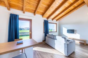 a living room with a couch and a table at LAS RIBERAS. APARTAMENTOS RURALES in Oviñana