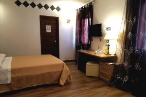 a hotel room with a bed and a desk and a table at Sunset Bed & Breakfast in Peschici