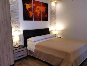 a bedroom with a bed with two lamps and a painting at Sunset Bed & Breakfast in Peschici