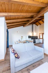 a white couch in a living room with wooden ceilings at LAS RIBERAS. APARTAMENTOS RURALES in Oviñana +24 photos