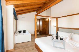 um quarto com uma cama branca e um tecto de madeira em LAS RIBERAS. APARTAMENTOS RURALES em Oviñana