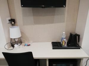 a white table with a lamp and a stove at Les Chambres de la Place in Sanremo