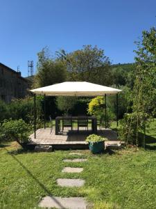 a picnic shelter with a picnic table and a bench at Residence Le petit paradis - La petite maison in Labastide-Rouairoux +13 photos