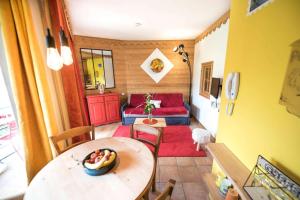 uma pequena sala de estar com uma mesa e um sofá em La Carte Postale em Duingt
