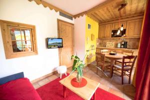 Una sala de estar con un sofá rojo y una mesa. en La Carte Postale, en Duingt