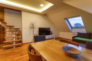 een woonkamer met een eettafel en een tv bij Top Rest - Vila Borova in Zlatibor